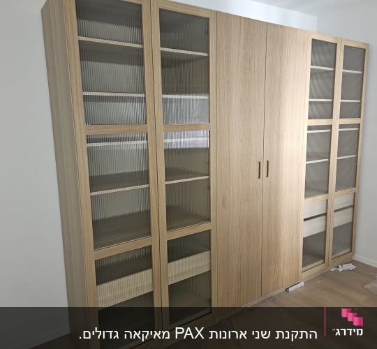 ארון עץ עם דלתות זכוכית בחדר ריק